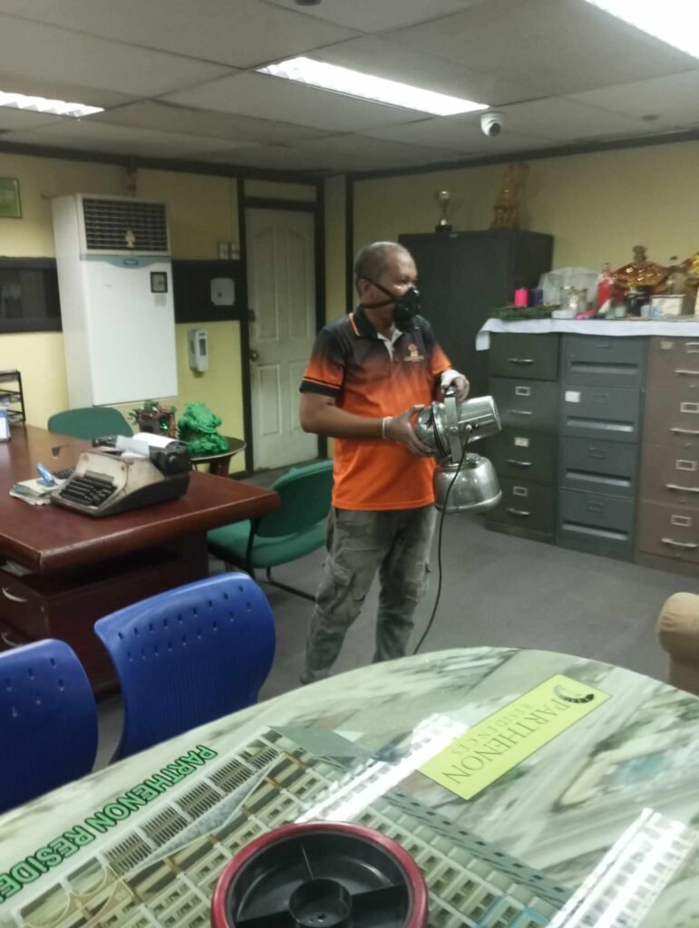 antique pest control Technician in protective gear fogging an office for pest control in Antique.